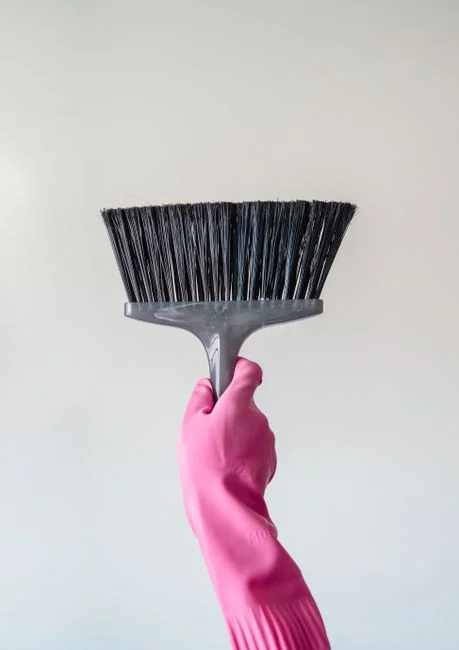 Asian couple having fun while cleaning their home, enhancing a cheerful atmosphere.
